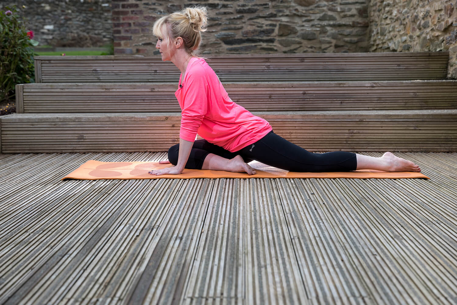 Women practising yoga outdoors on non-slip timber decking